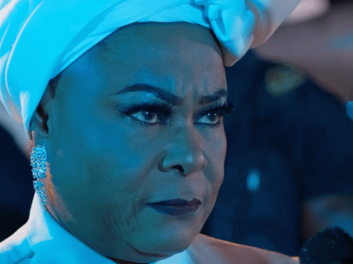 A Woman Wearing A White Turban And Earrings Looks Serious GIF