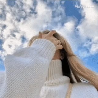 A Woman Wearing A White Turtleneck Sweater Is Looking Up At The Sky GIF