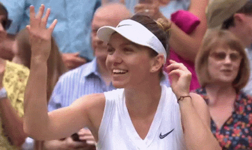 a woman wearing a white visor and a white tank top is smiling and waving at the crowd .