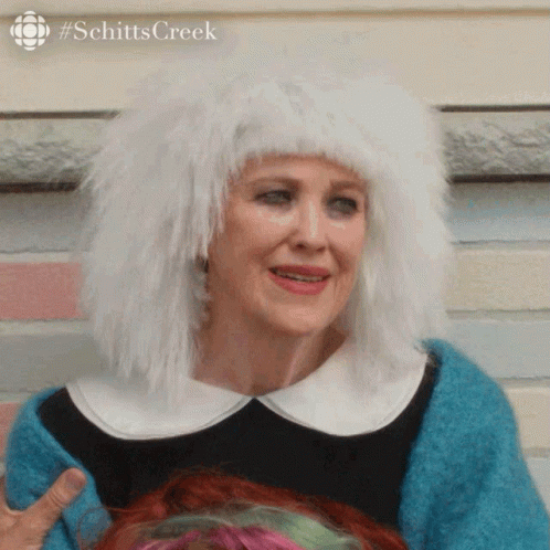 A Woman Wearing A White Wig And A Blue Sweater GIF