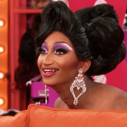 Woman Smiling With Wig And Heart Earrings GIF
