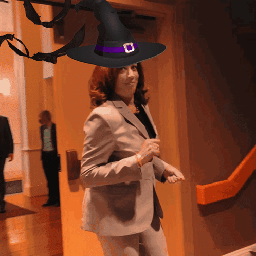 A Woman Wearing A Witch Hat With A Purple Stripe GIF