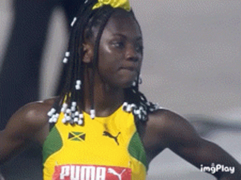 A Woman Wearing A Yellow And Green Puma Jersey GIF
