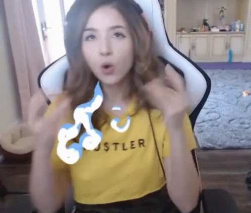 A Woman Wearing A Yellow Hustler Shirt Sitting In A Chair GIF