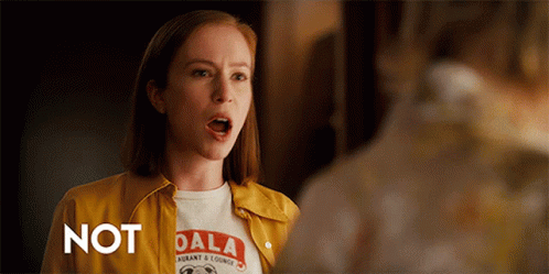 A Woman Wearing A Yellow Jacket And A Dala Shirt GIF