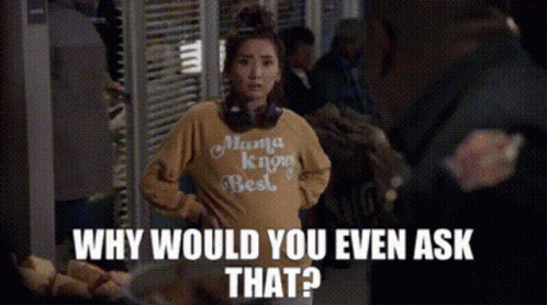 A Woman Wearing A Yellow Shirt That Says Mama Knows Best Is Standing In Front Of A Crowd Of People . GIF