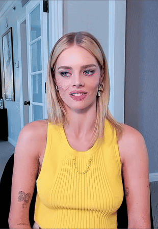 A Woman Wearing A Yellow Tank Top Has A Tattoo On Her Arm GIF