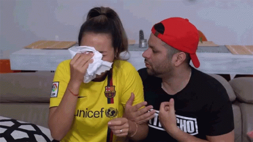 A Woman Wearing A Yellow Unicef Shirt Is Crying GIF