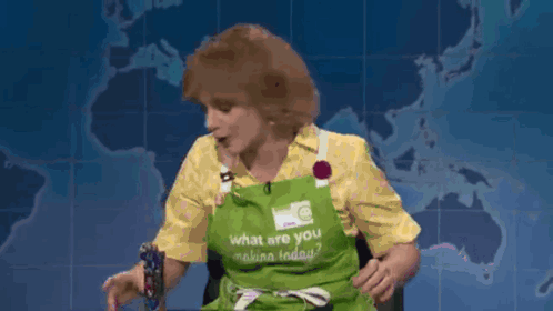 A Woman Wearing An Apron That Says What Are You Making Today GIF