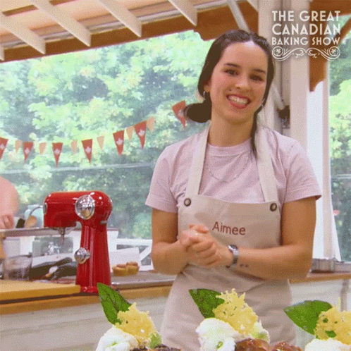 A Woman Wearing An Apron With Aimee Written On It GIF