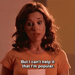 A Woman Wearing An Orange T-Shirt Says But I Can 'T Help It That I 'M Popular GIF
