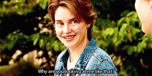 A Woman Wearing An Oxygen Mask Is Smiling While Talking To A Man . GIF