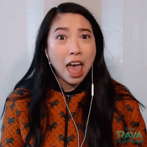 A Woman Wearing Earphones Is Making A Funny Face . GIF