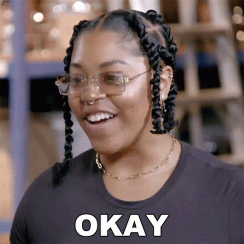 A Woman Wearing Glasses And A Black Shirt Is Smiling And Says Okay GIF
