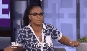 A Woman Wearing Glasses And A Blue Shirt Is Sitting On A Couch . GIF