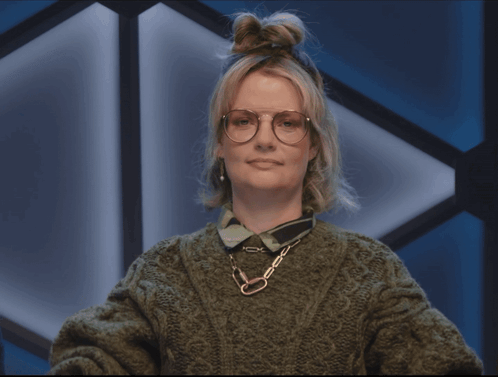 A Woman Wearing Glasses And A Green Sweater Making A Face GIF