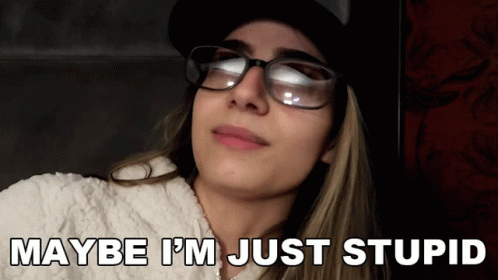 A Woman Wearing Glasses And A Hat With The Words Maybe I 'M Just Stupid Below Her GIF