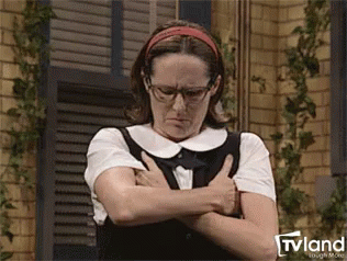 A Woman Wearing Glasses And A Headband Is Standing With Her Arms Crossed And Looking Down . GIF