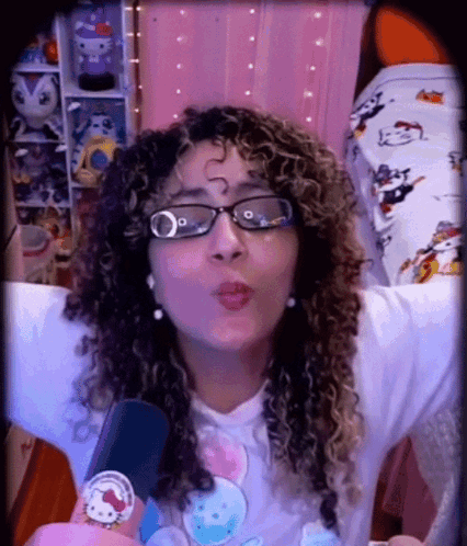 A Woman Wearing Glasses And A Hello Kitty Shirt GIF