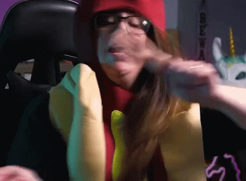 A Woman Wearing Glasses And A Hot Dog Costume Is Making A Face GIF
