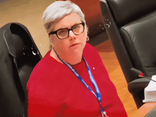 A Woman Wearing Glasses And A Lanyard That Says ' European Union ' GIF