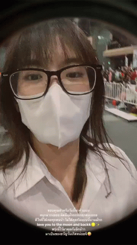 A Woman Wearing Glasses And A Mask Has A Message In Another Language GIF