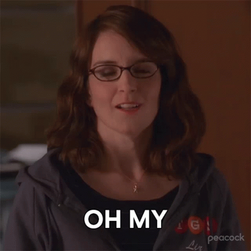 A Woman Wearing Glasses And A Peacock Sweatshirt Says " Oh My " GIF