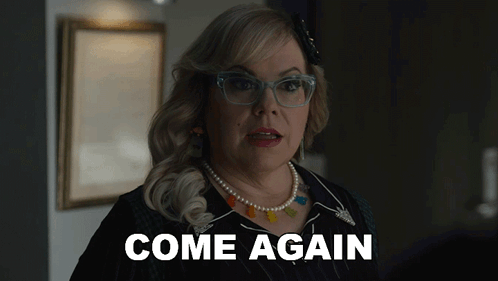 A Woman Wearing Glasses And A Pearl Necklace Is Saying Come Again GIF