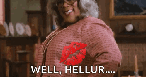 A Woman Wearing Glasses And A Pink Shirt Is Giving A Kiss With The Words `` Well , Hellur ... '' . GIF