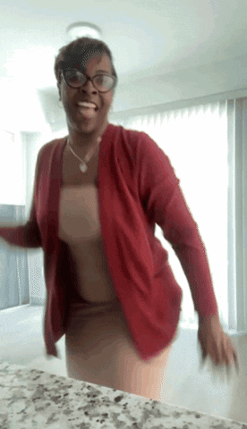 A Woman Wearing Glasses And A Red Cardigan Dancing GIF