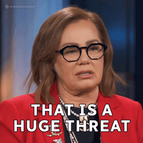 A Woman Wearing Glasses And A Red Jacket Says " That Is A Huge Threat " GIF