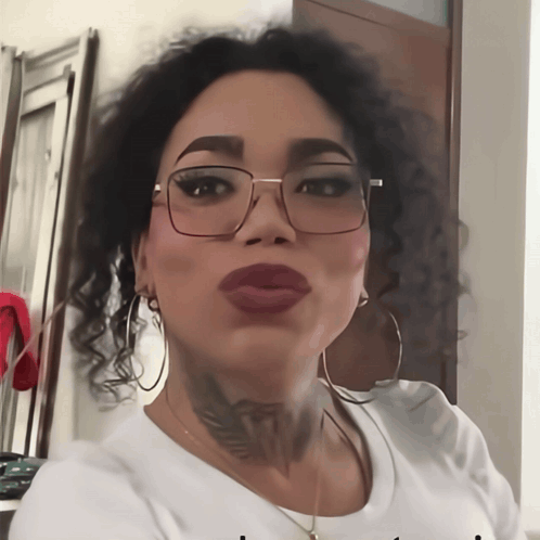 a woman wearing glasses and a white shirt has a tattoo on her neck that says " i love you "