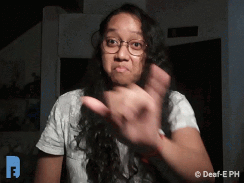A Woman Wearing Glasses And A White Shirt Is Making A Funny Face GIF