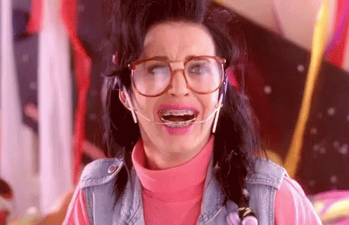 A Woman Wearing Glasses And Braces Is Making A Face . GIF