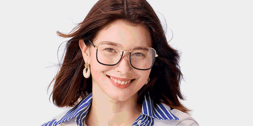 A Woman Wearing Glasses And Earrings Is Smiling GIF