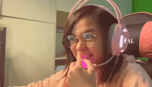 A Woman Wearing Glasses And Headphones Is Making A Face GIF