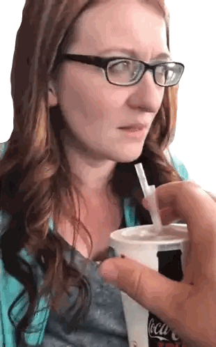 a woman wearing glasses is drinking a coca cola through a straw