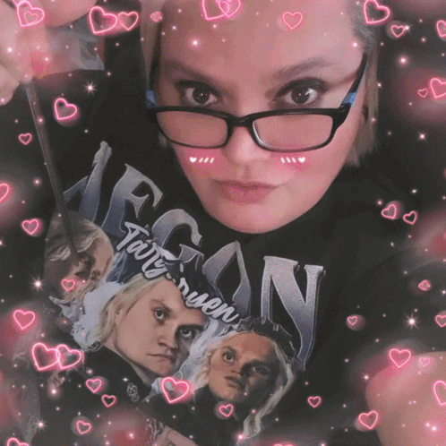 A Woman Wearing Glasses Is Holding A Book That Says Egon GIF