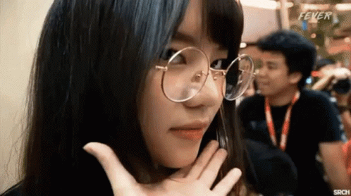 A Woman Wearing Glasses Is Making A Funny Face While A Man Takes A Picture Of Her . GIF