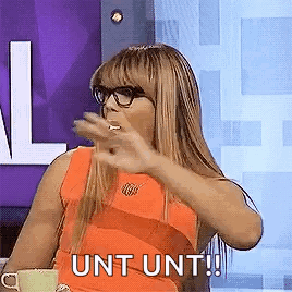 A Woman Wearing Glasses Is Sitting At A Table With A Cup Of Coffee . GIF