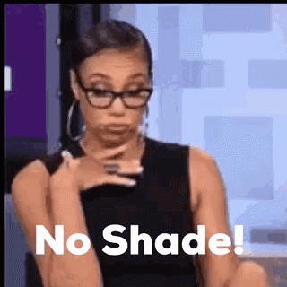 A Woman Wearing Glasses Is Sitting Down With Her Hand On Her Chin And The Words `` No Shade '' Written Above Her . GIF