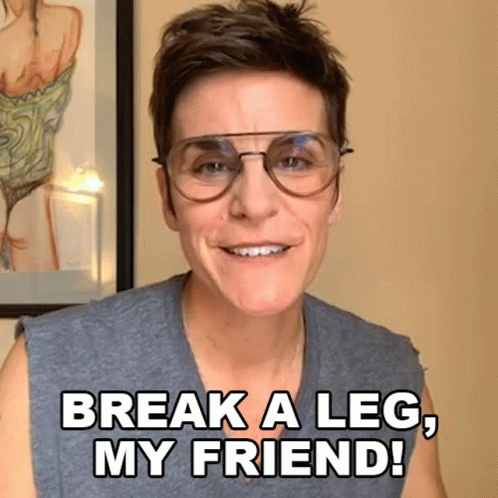 A Woman Wearing Glasses Is Smiling And Saying Break A Leg My Friend GIF