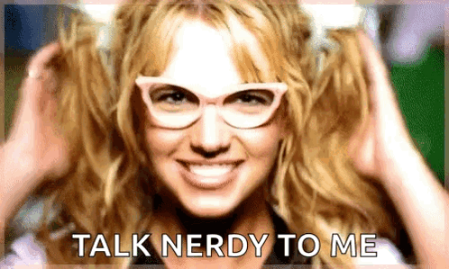 A Woman Wearing Glasses Is Smiling And Says Talk Nerdy To Me GIF