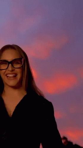 A Woman Wearing Glasses Is Sticking Out Her Tongue . GIF