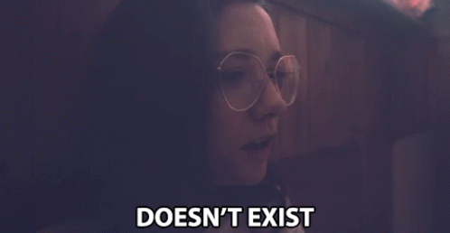 A Woman Wearing Glasses Says " Doesn 'T Exist " In A Dark Room GIF