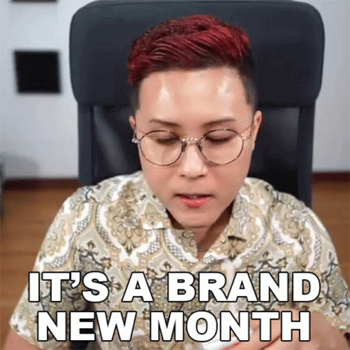 A Woman Wearing Glasses Says It 'S A Brand New Month While Sitting In A Chair GIF