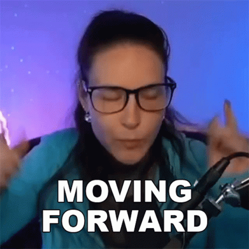 A Woman Wearing Glasses Says Moving Forward In Front Of A Microphone . GIF
