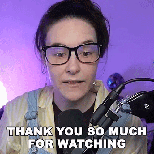A Woman Wearing Glasses Stands In Front Of A Microphone Saying Thank You So Much For Watching GIF
