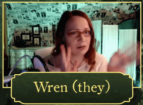 A Woman Wearing Glasses Talks Into A Microphone With The Words Wren ( They ) Above Her GIF