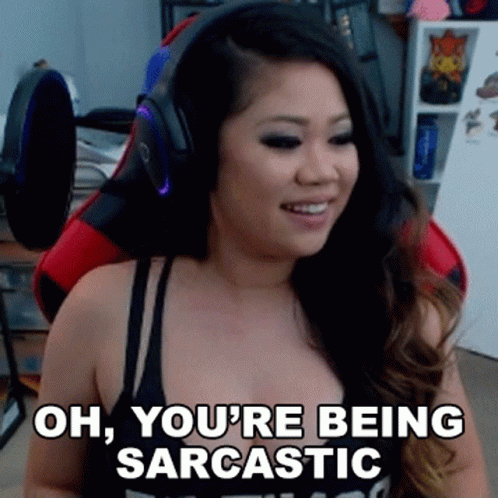 A Woman Wearing Headphones And A Black Tank Top Is Sitting In A Gaming Chair . GIF